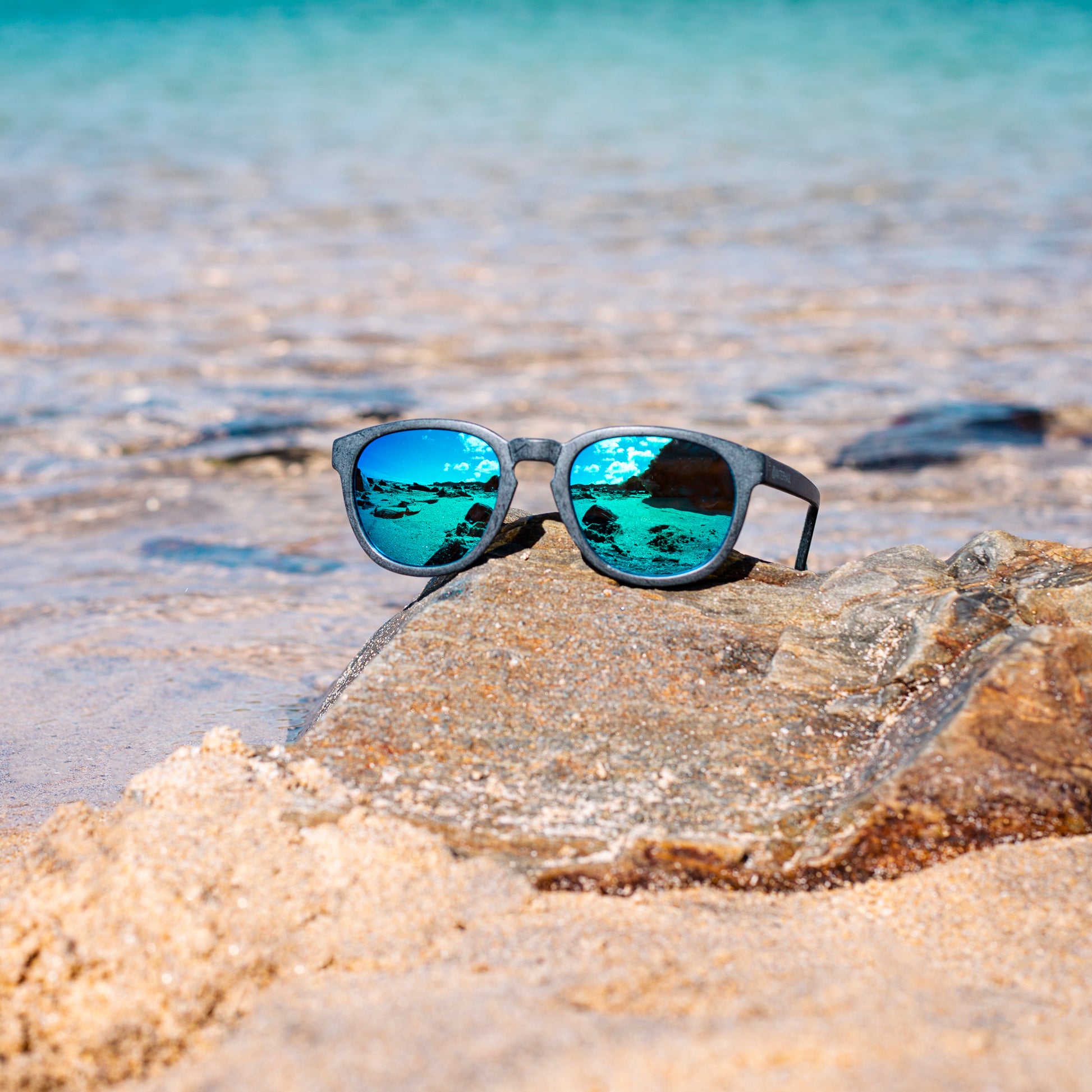 CRANTOCK SLATE Sunglasses - Blue Mirror Lenses On Rock Beach & Sea